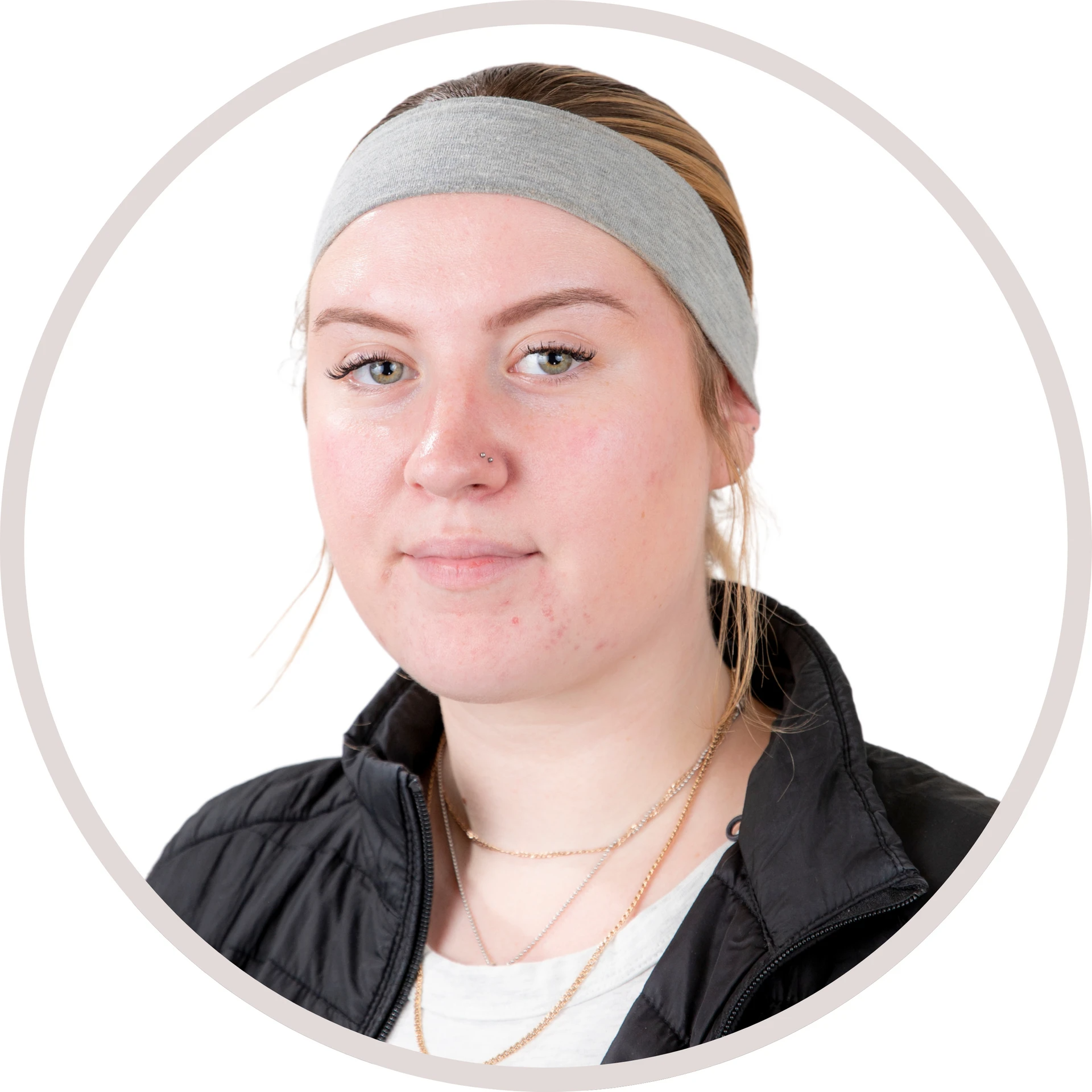 Woman wearing a grey headband and black jacket, facing forward.
