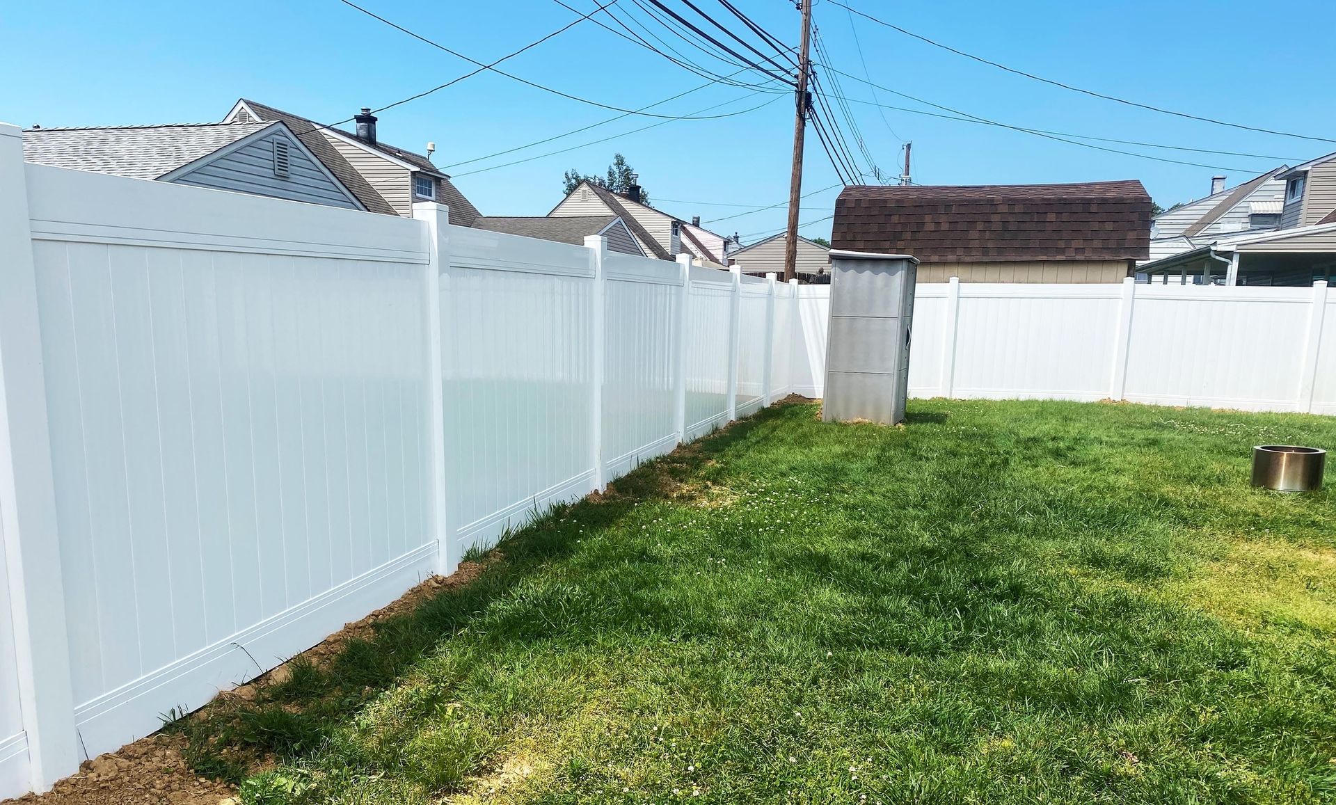 A white fence surrounds a lush green yard.