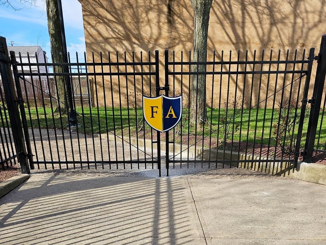A black fence with a yellow and blue shield on it.