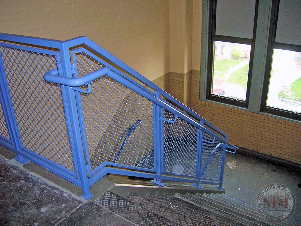 A staircase with a blue railing and a window