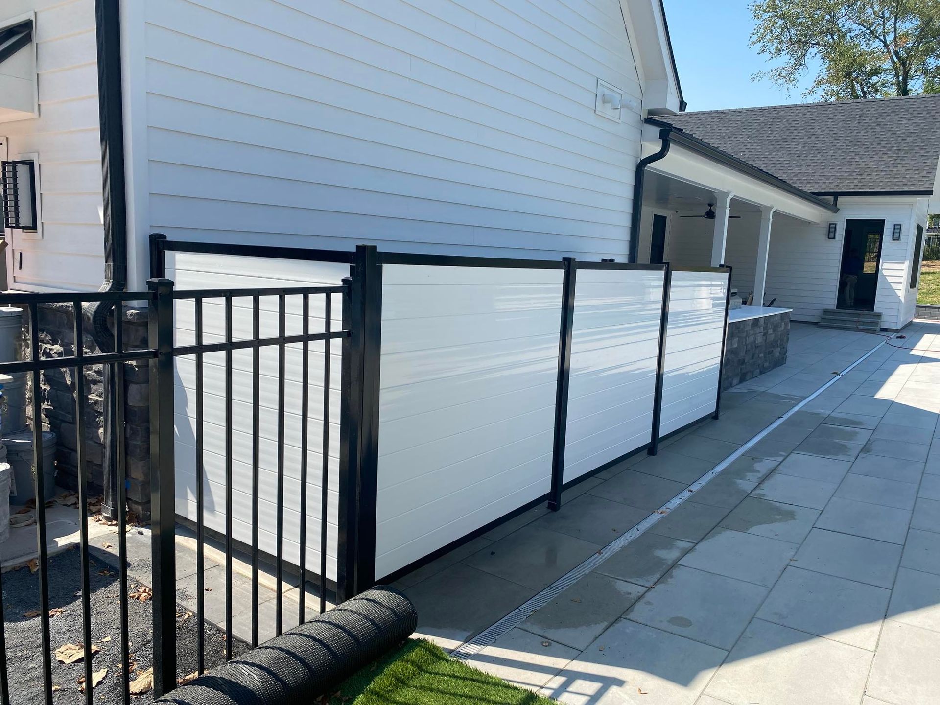 A white house with a black fence in front of it.