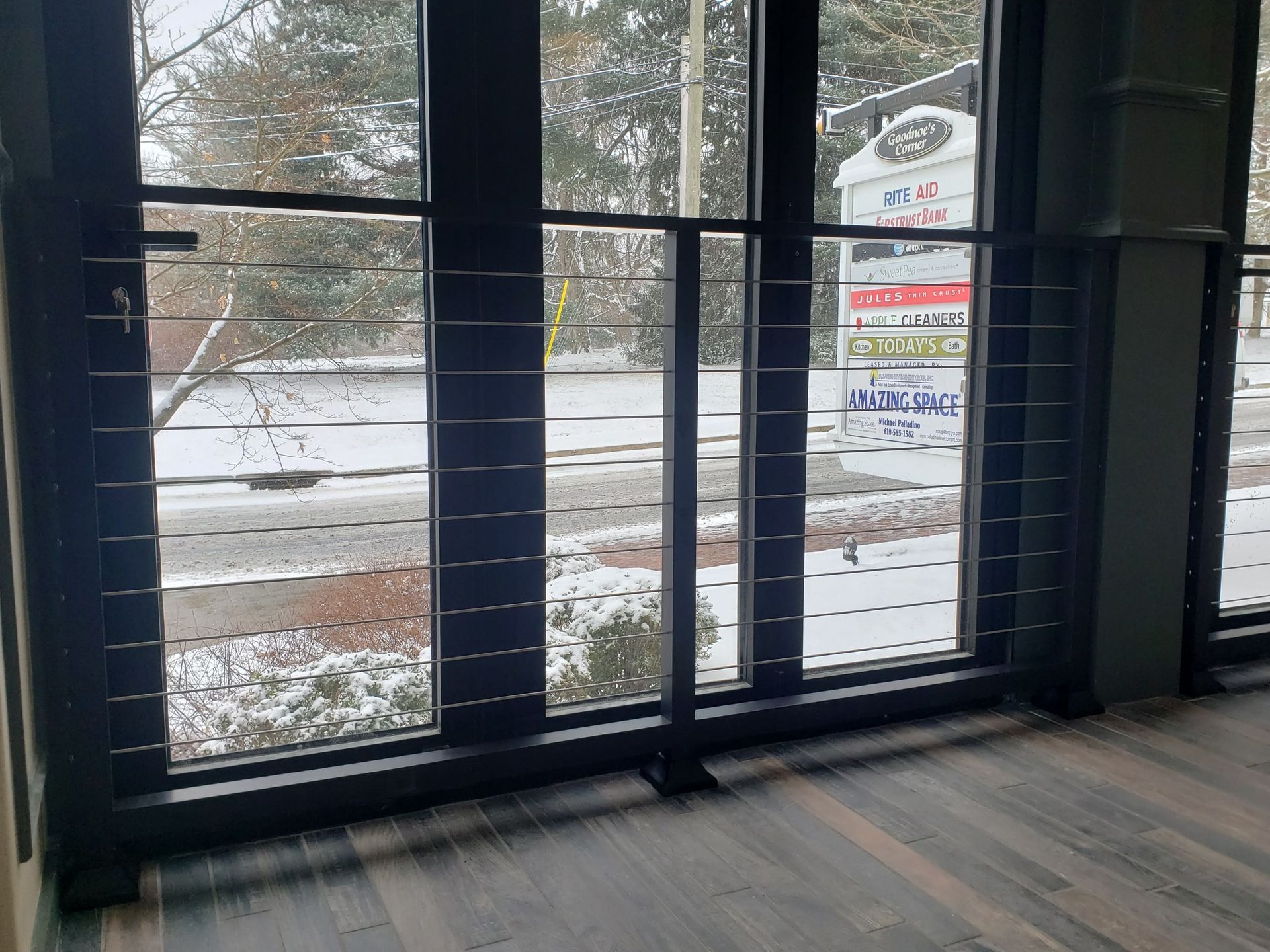An empty room with a view of a snowy street through a window.