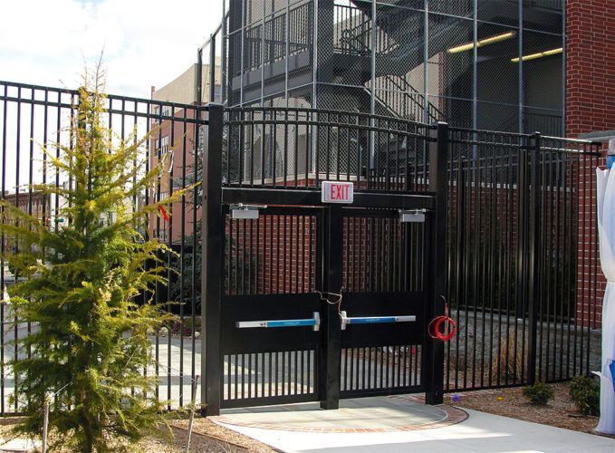 A black gate with a red exit sign on it