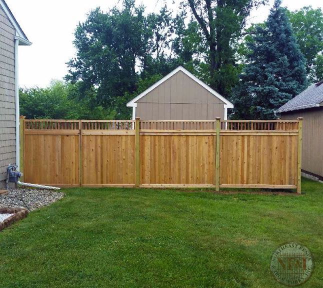A wooden fence with a shed in the background