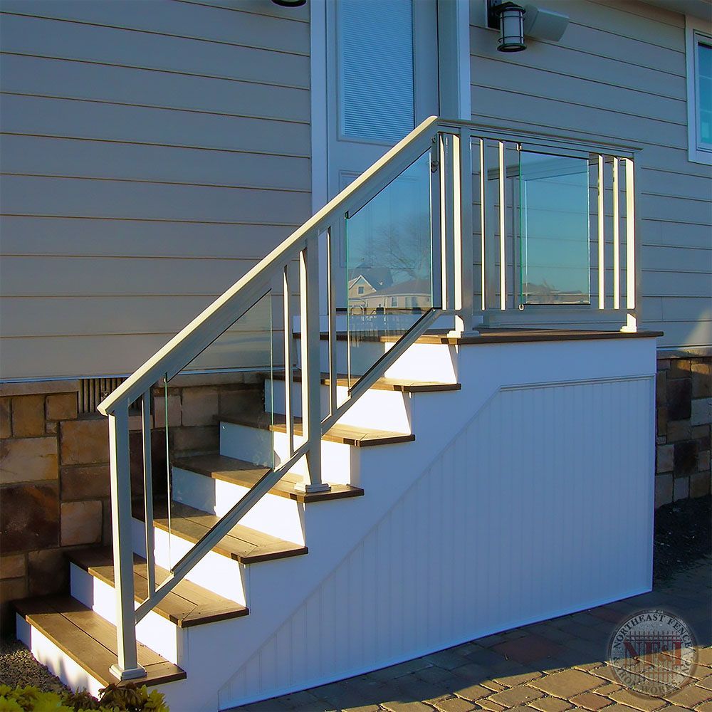 A white house with stairs and a glass railing