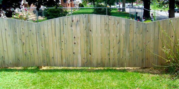 A wooden fence is sitting on top of a lush green lawn.