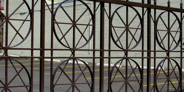 A close up of a wrought iron gate in front of a building.