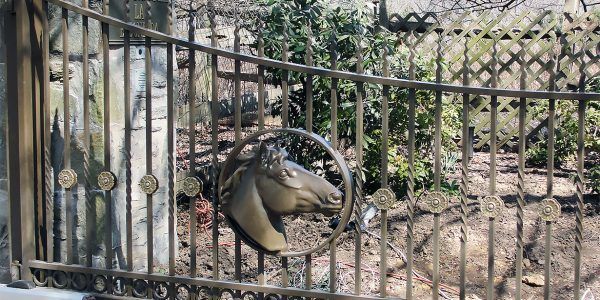 A wrought iron gate with a horse head on it