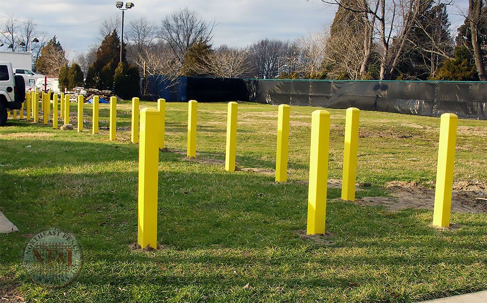 A row of yellow poles in a grassy field