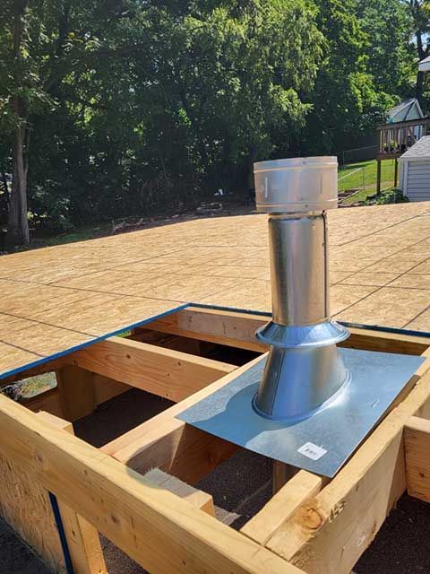 A metal pipe is sitting on top of a wooden structure.