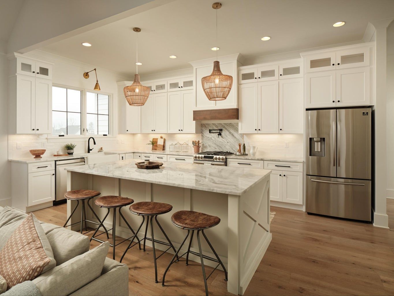 A kitchen with white cabinets , stainless steel appliances , and a large island.