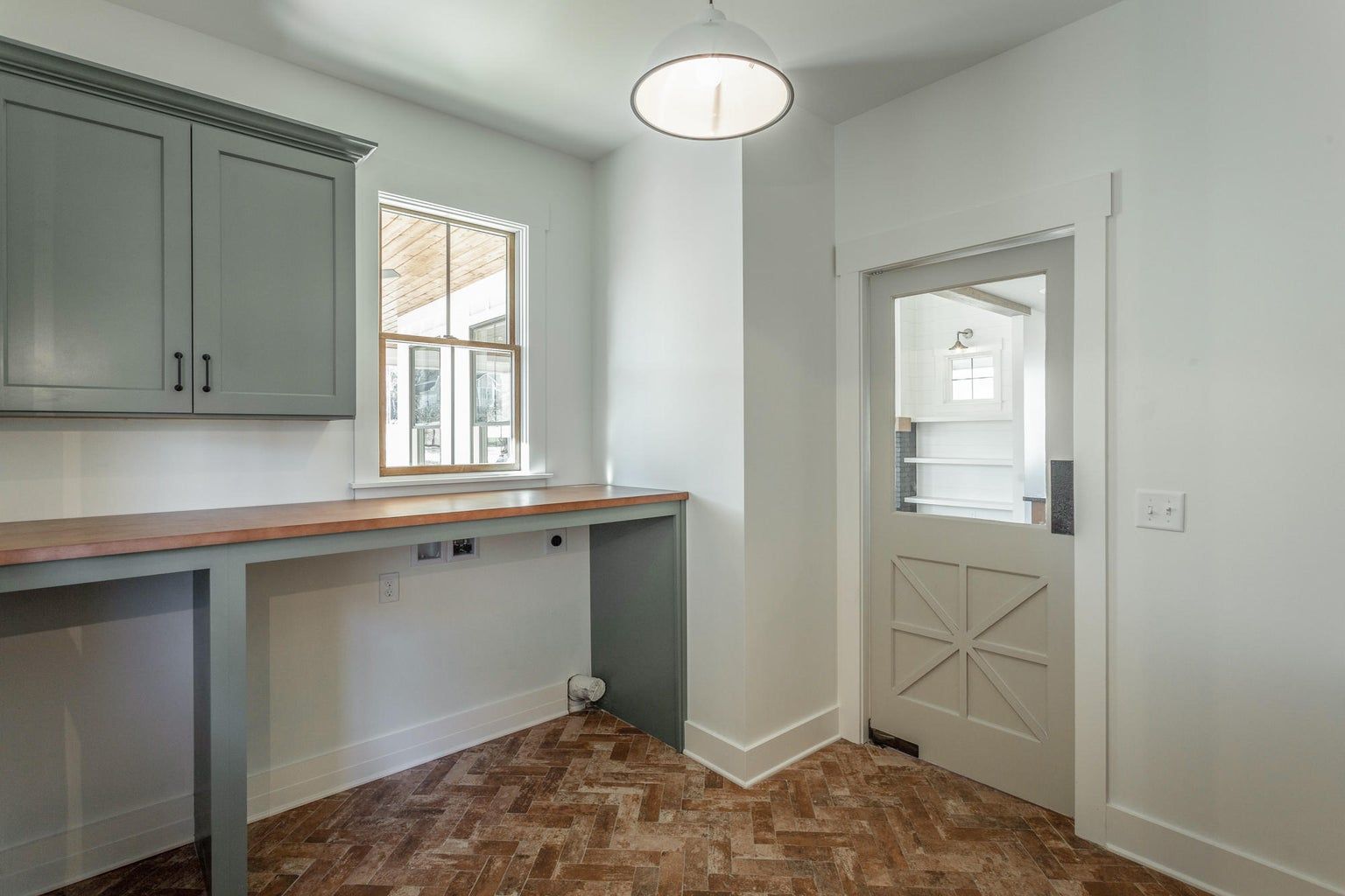 A laundry room with a wooden table and a window.