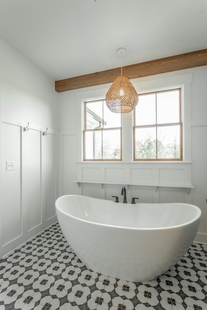 A bathroom with a bathtub and a window.