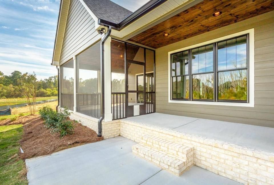 a house with a screened in porch and a large window .