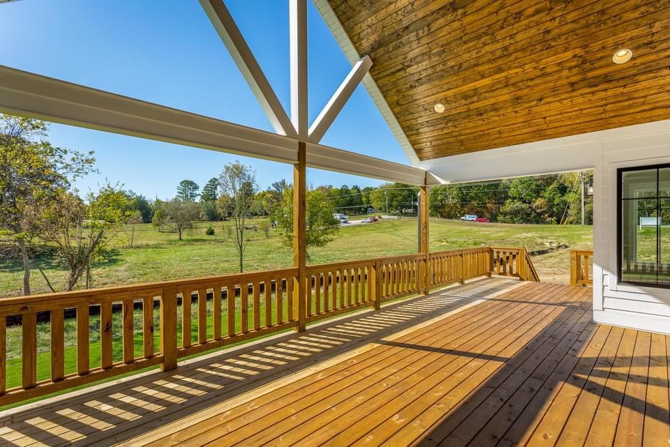 a large wooden deck with a view of a field .