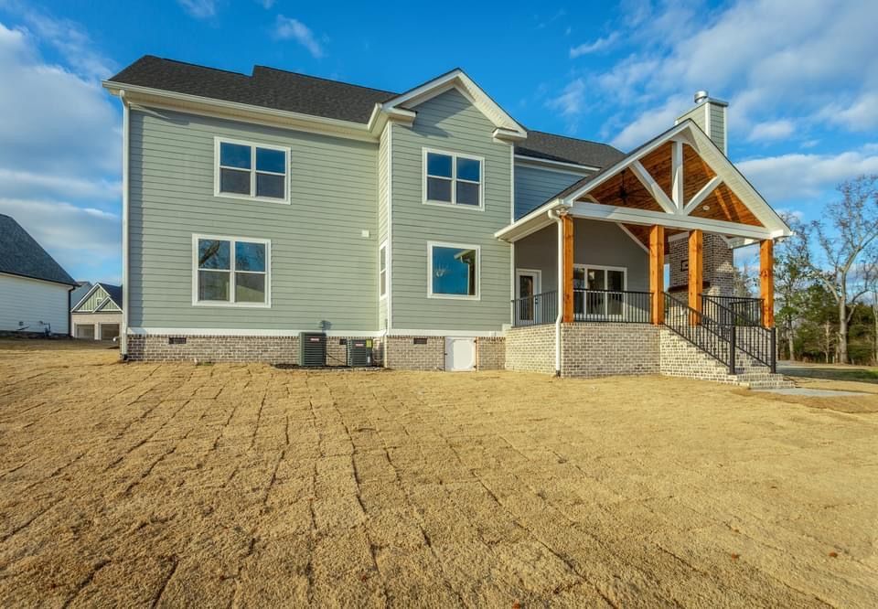 a large house with a lot of windows is sitting on top of a dirt field .