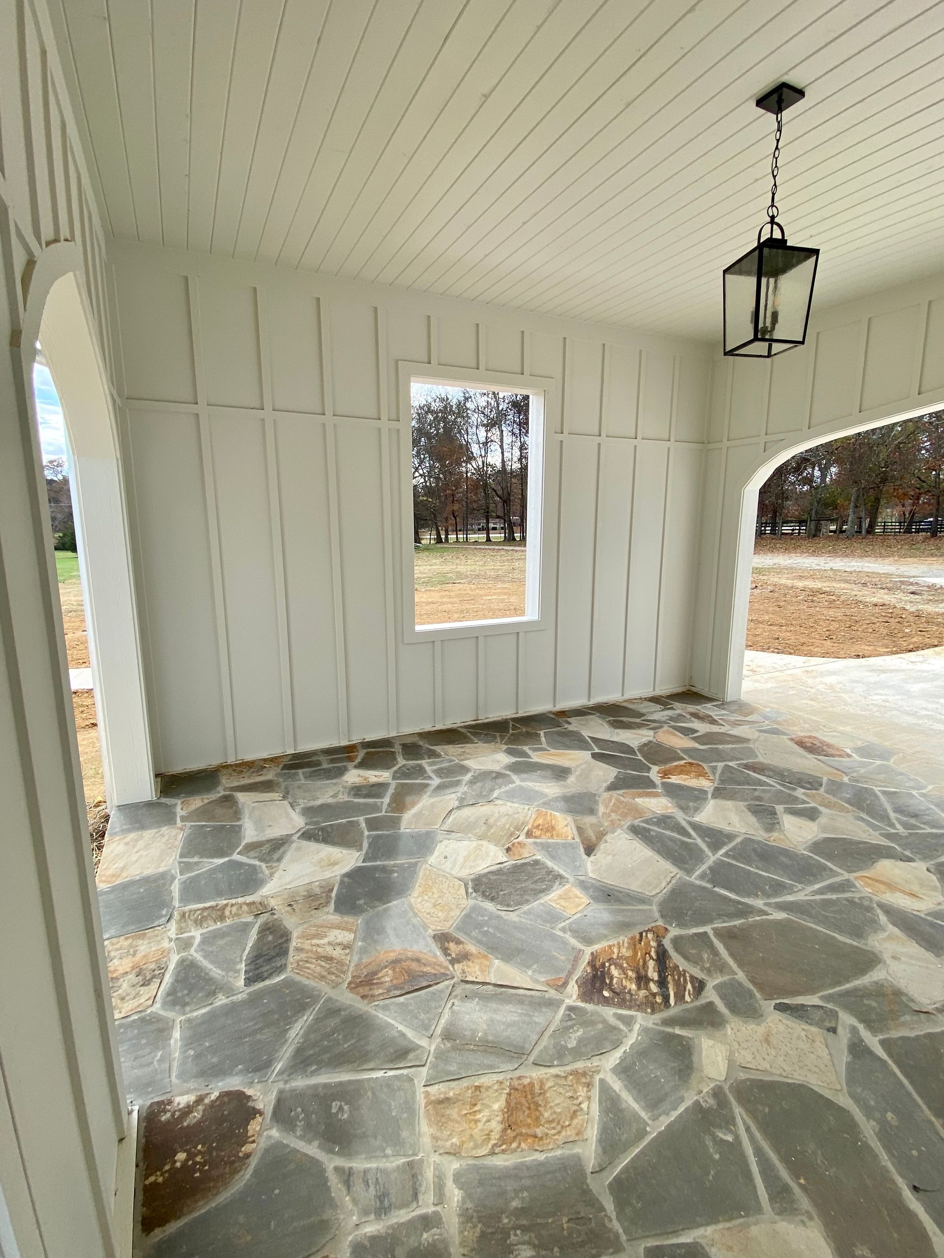 A room with a window and a lantern hanging from the ceiling.