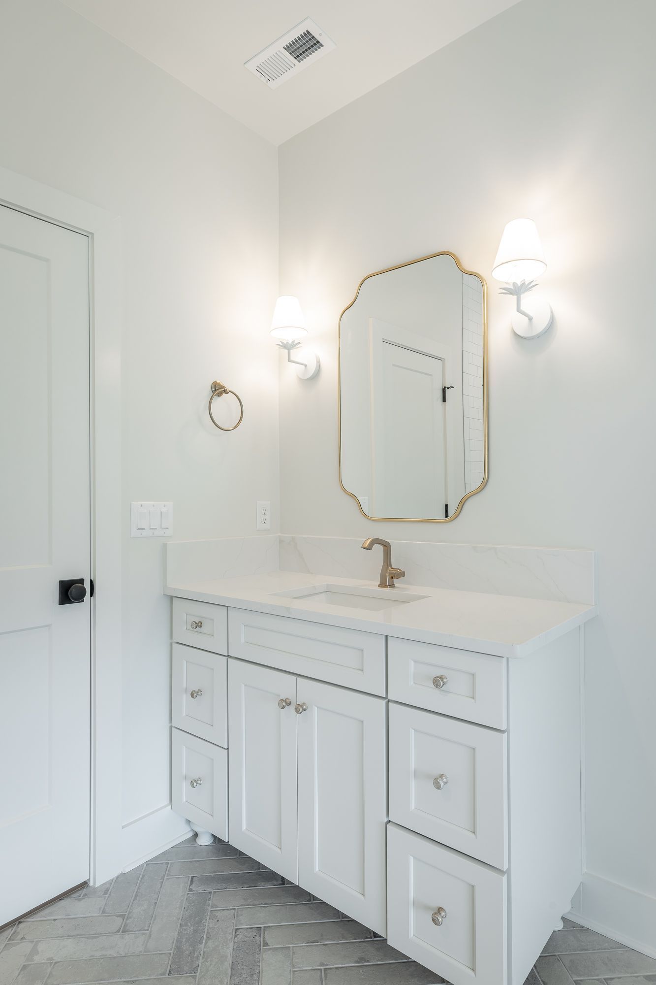 A bathroom with a sink , mirror and drawers.