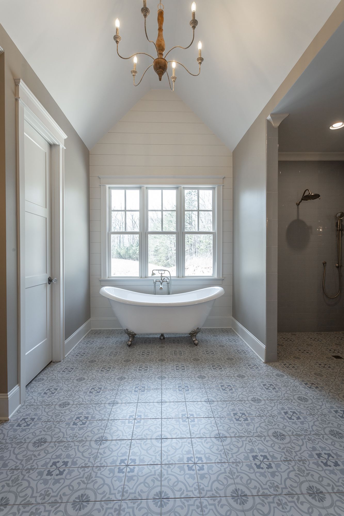 A bathroom with a claw foot tub and a chandelier hanging from the ceiling.