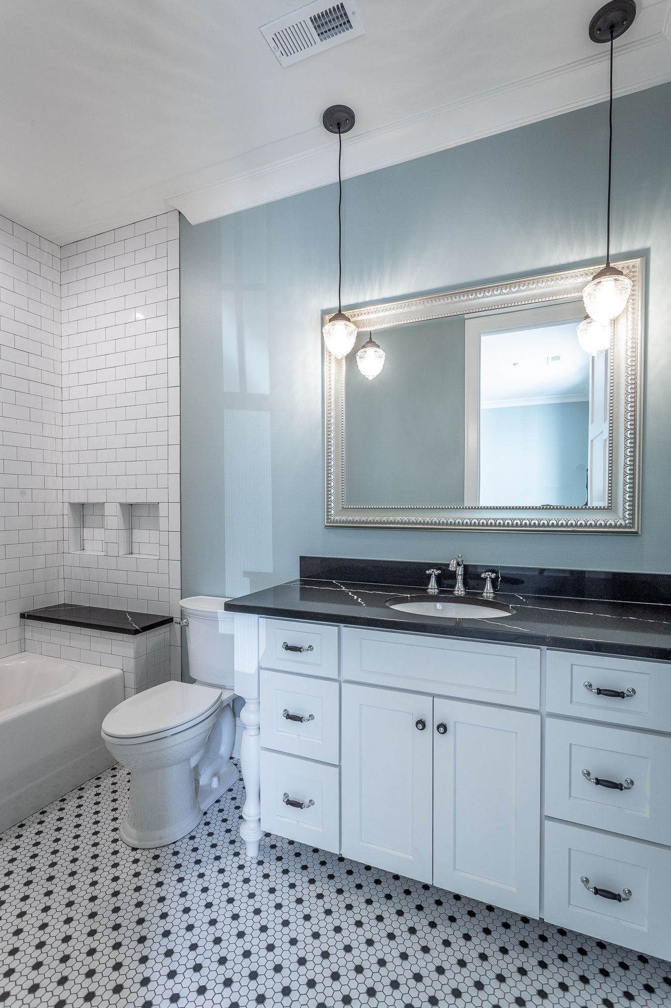 A bathroom with a toilet , sink , mirror and bathtub.
