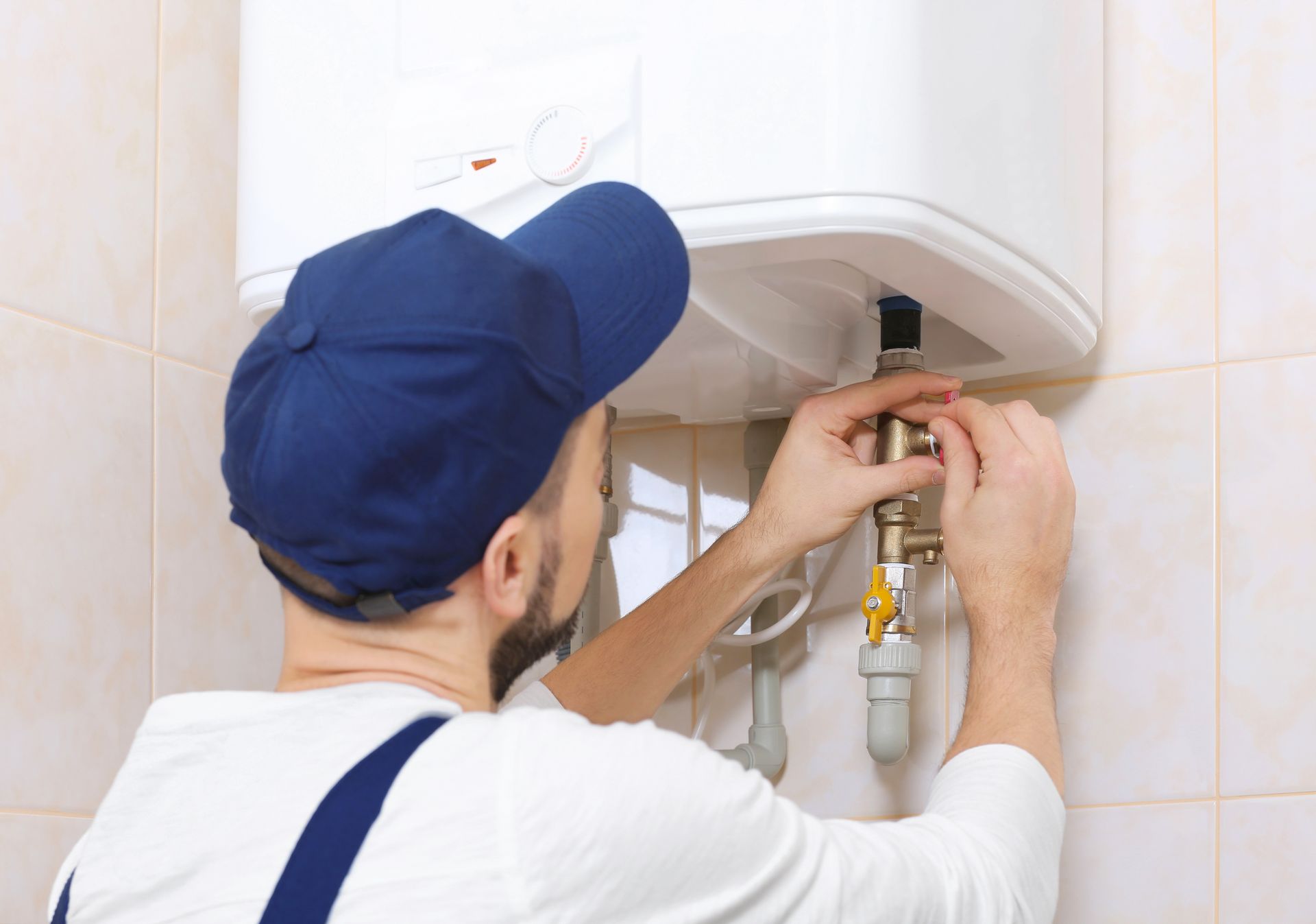 Skilled plumber installing a new water heater in a residential bathroom, ensuring efficient hot water supply.