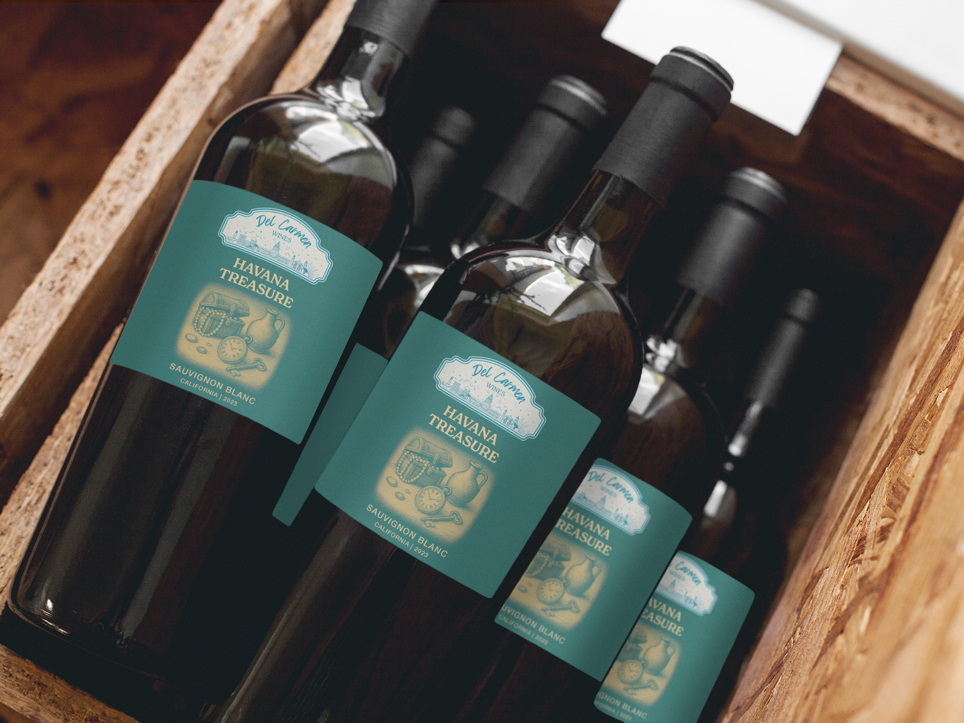 A crate containing four bottles of dark wine or oil, each featuring a sage green rectangular label with illustrated fruit.