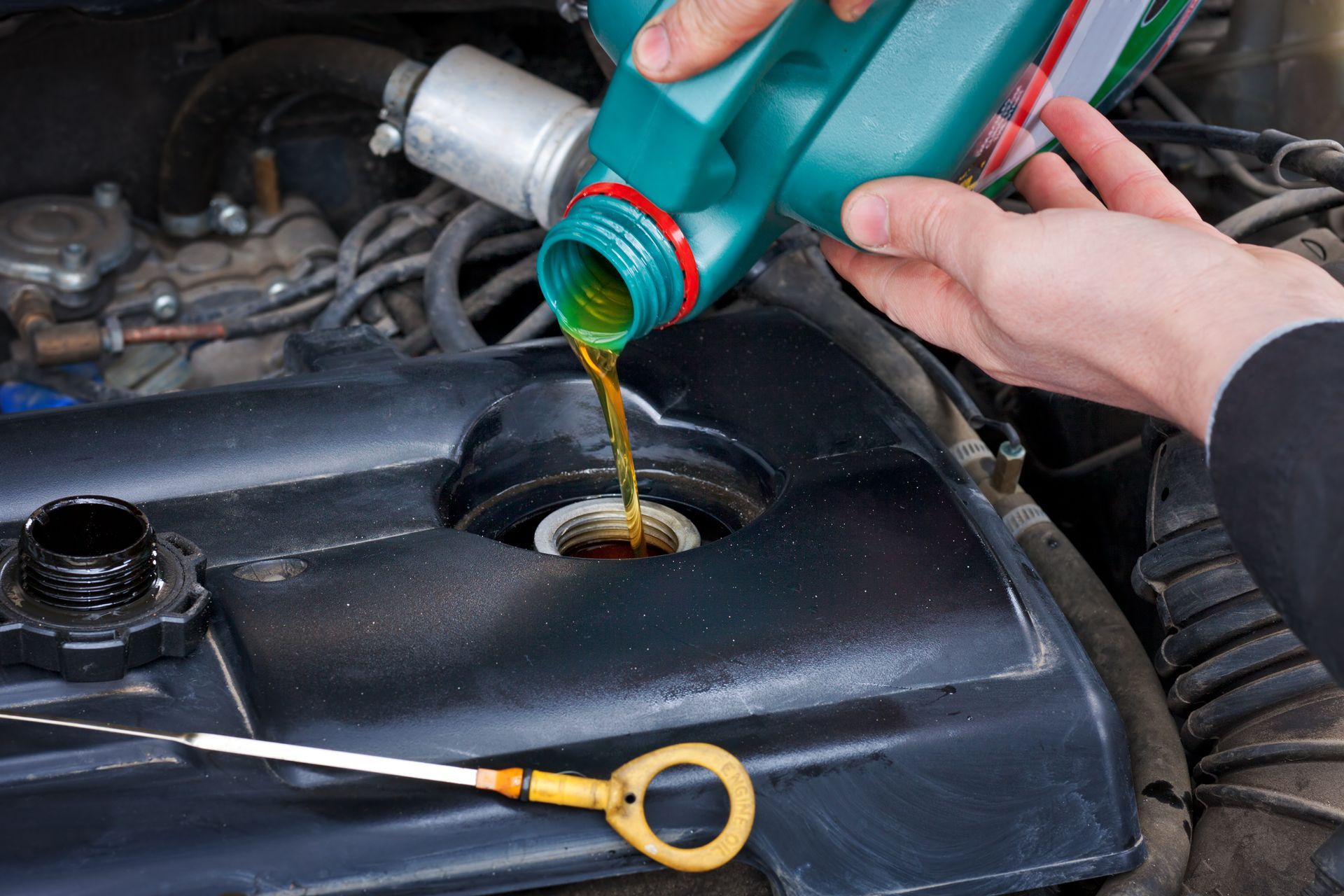 A Person is Pouring oil into a Car Engine | Colorado Springs, CO | Locklynn Automotive