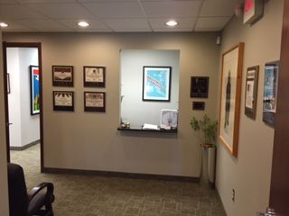 A waiting room with a chair and pictures on the wall