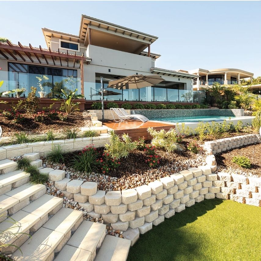 Modern house with pool and tiered landscaping, featuring stairs and retaining walls - Palms Landscape Supplies in Forster, NSW
