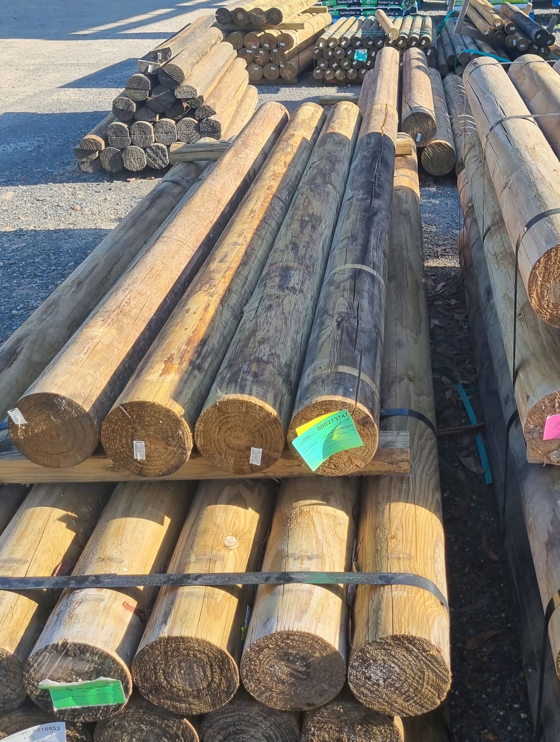 Stacks of weathered wooden posts - Palms Landscape Supplies in Forster, NSW