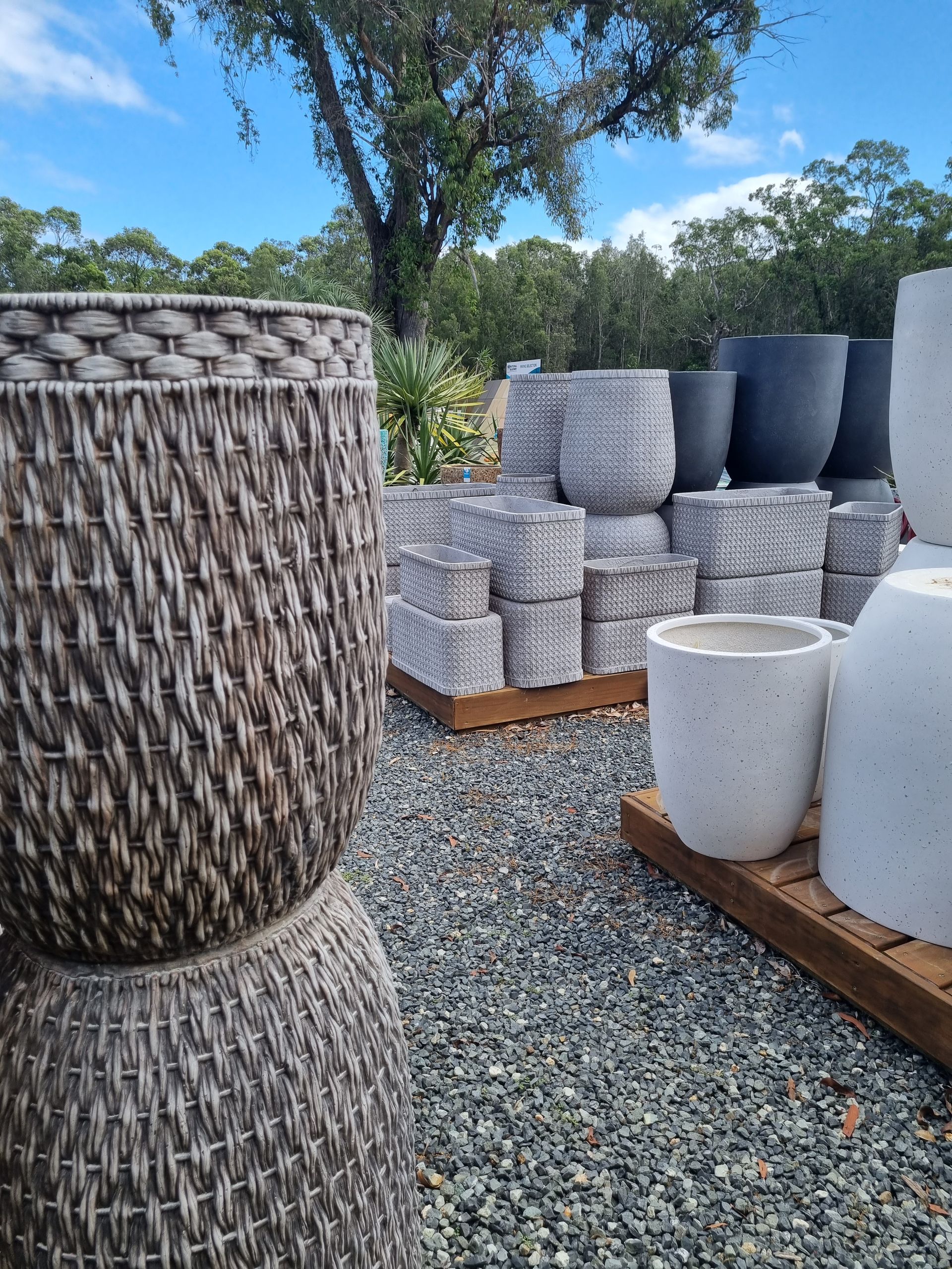 Outdoor display of various textured and coloured planters - Palms Landscape Supplies in Forster, NSW