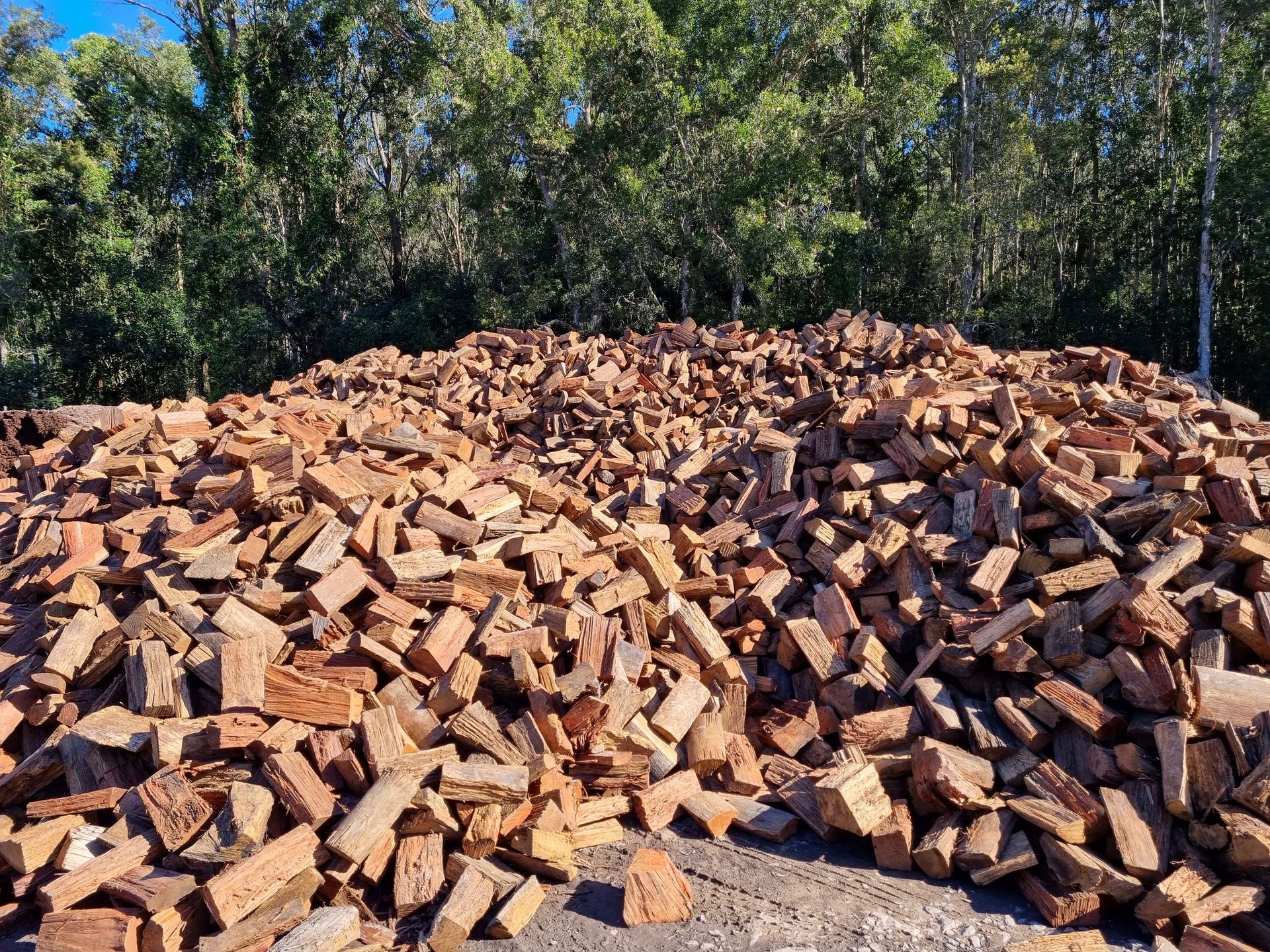 Pile of red bricks in front of trees - Palms Landscape Supplies in Forster, NSW