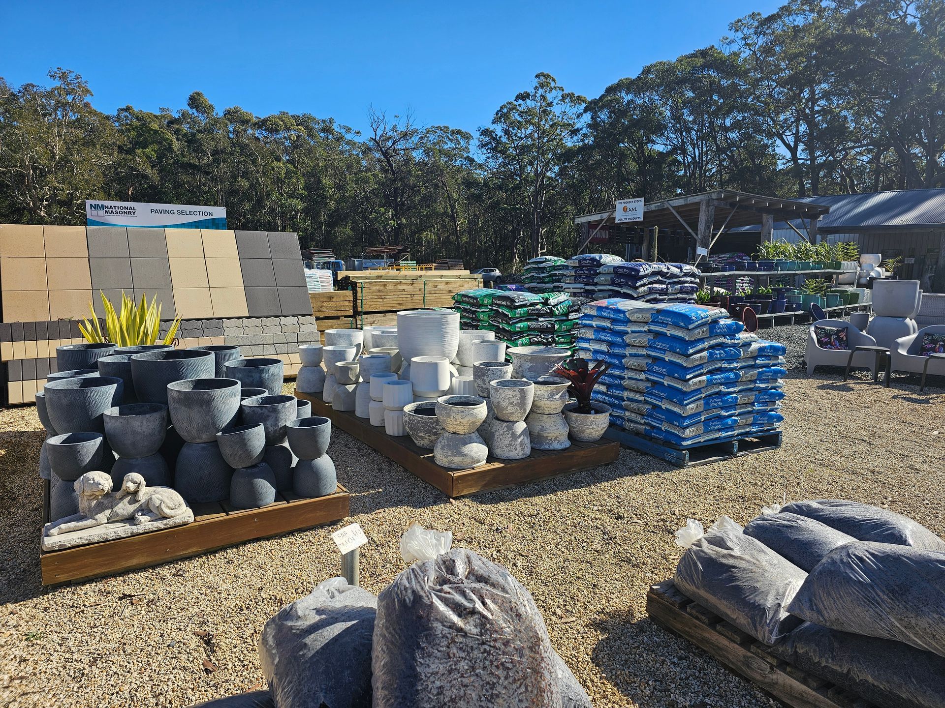 Outdoor garden centre display of pots, pavers, and soil bags. Sunny day - Palms Landscape Supplies in Forster, NSW
