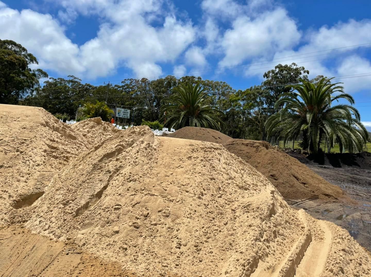 Sandy soil piles with tire tracks - Palms Landscape Supplies in Forster, NSW