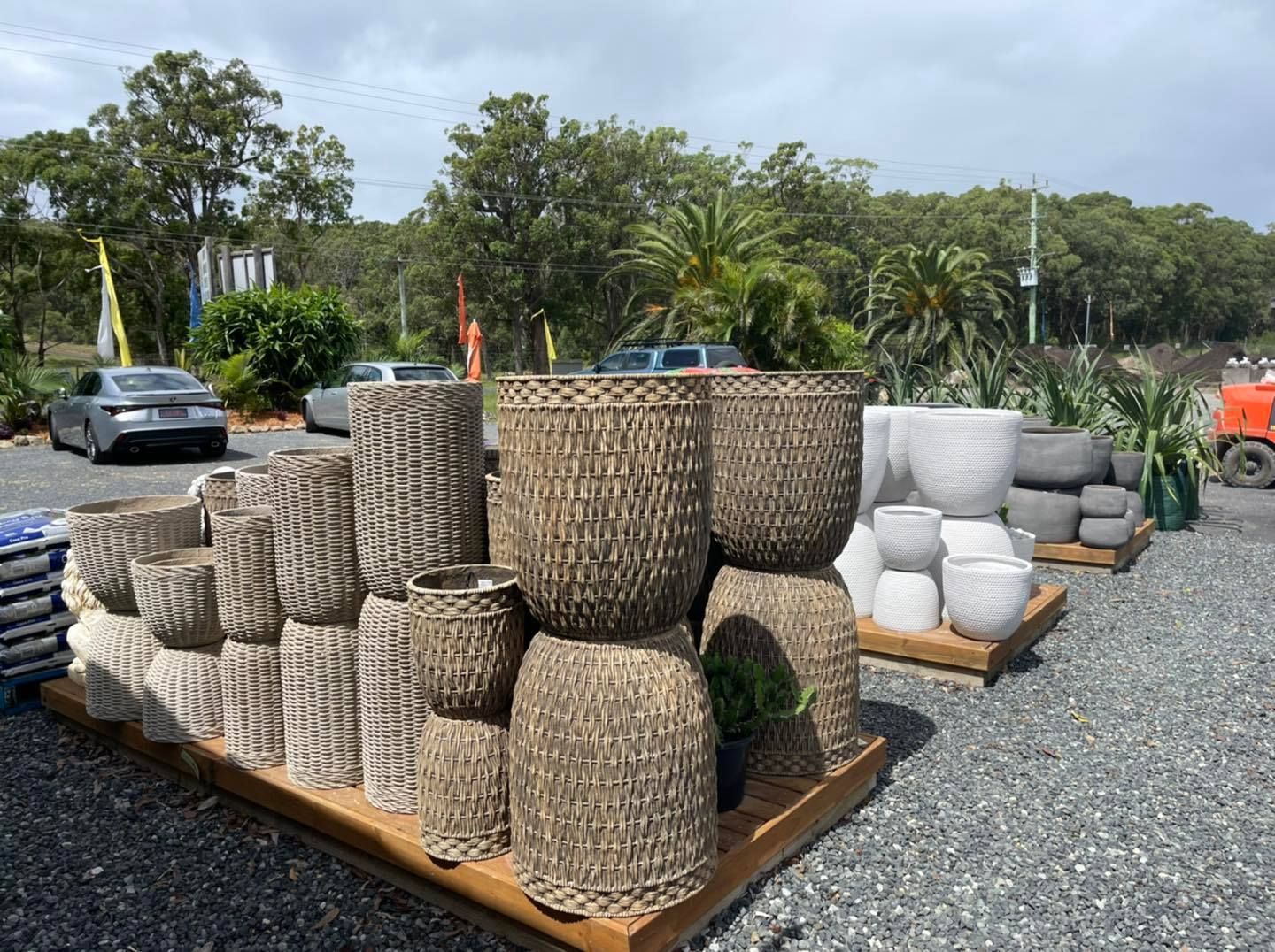 Assortment of woven and concrete planters displayed outdoors - Palms Landscape Supplies in Forster, NSW