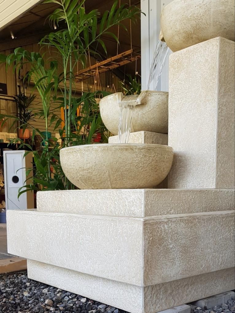 Water fountain made of light stone, cascading from top bowl to bottom - Palms Landscape Supplies in Forster, NSW