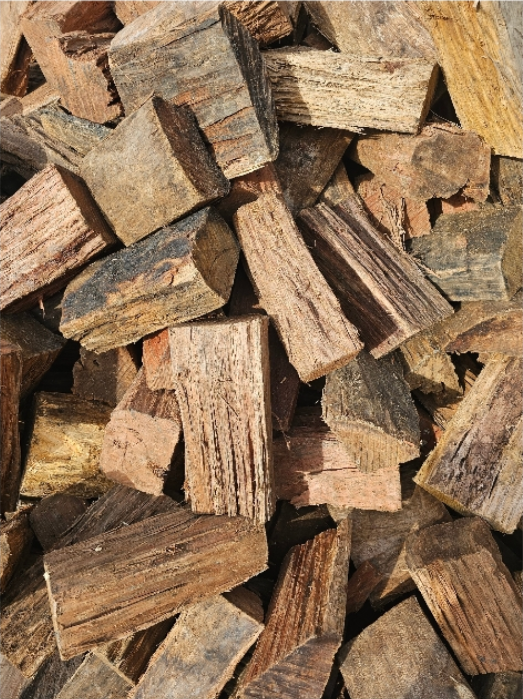 Pile of cut firewood logs, varying shades of brown, ready for burning - Palms Landscape Supplies in Forster, NSW