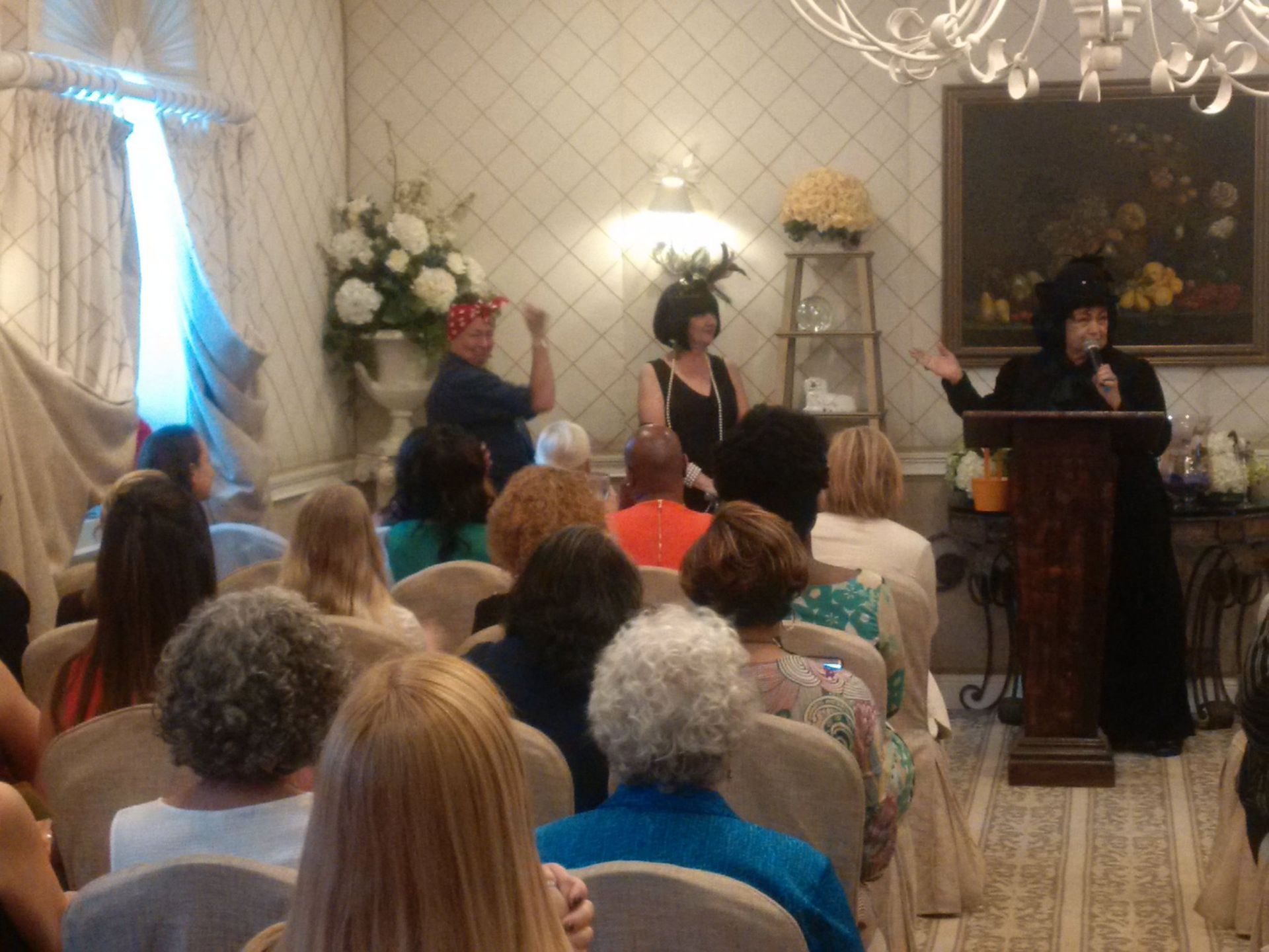 A woman is standing at a podium in front of a crowd of people.