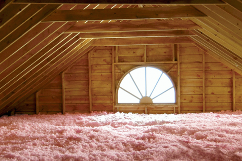 Attic insulation being installed: Workers blow in Owens Corning fiberglass insulation into attic .