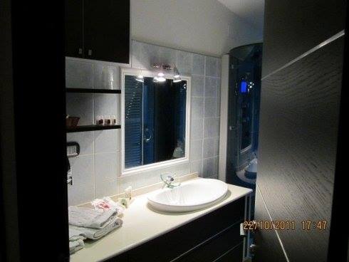 Bagno elegante di albergo con sanitari bianchi e porta nera