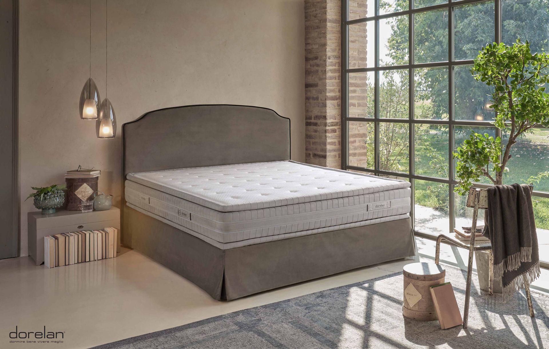 Un letto con materasso e testiera in una camera da letto accanto a una finestra.