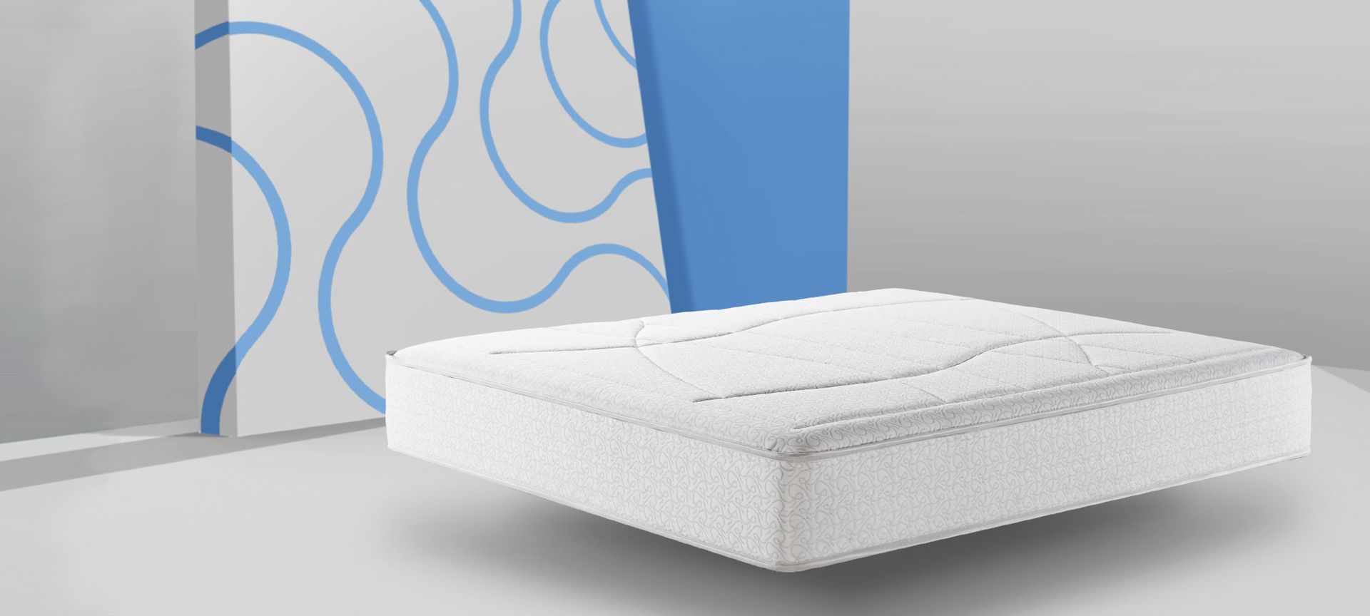 Un materasso bianco è appoggiato su un tavolo davanti a una parete blu.