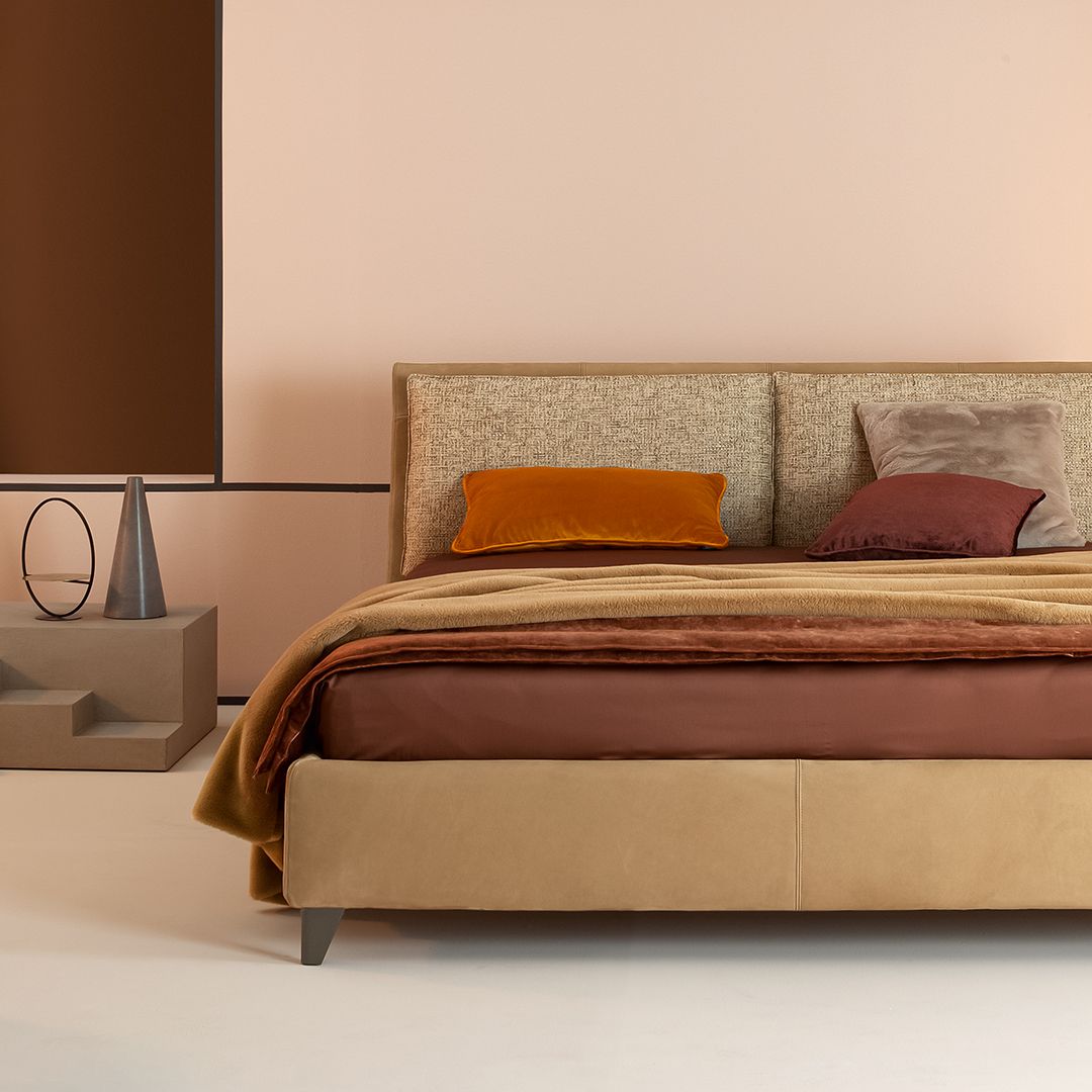 Un letto con una coperta e dei cuscini in una camera da letto