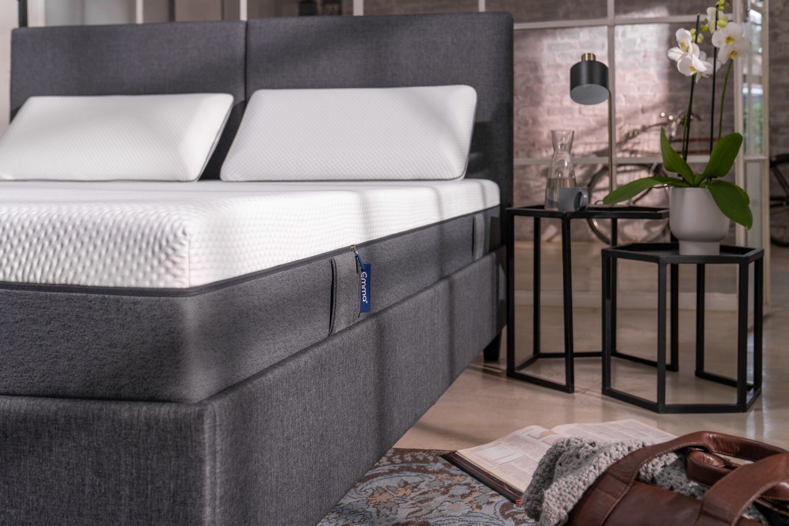 Un letto con materasso e cuscini in una camera da letto.