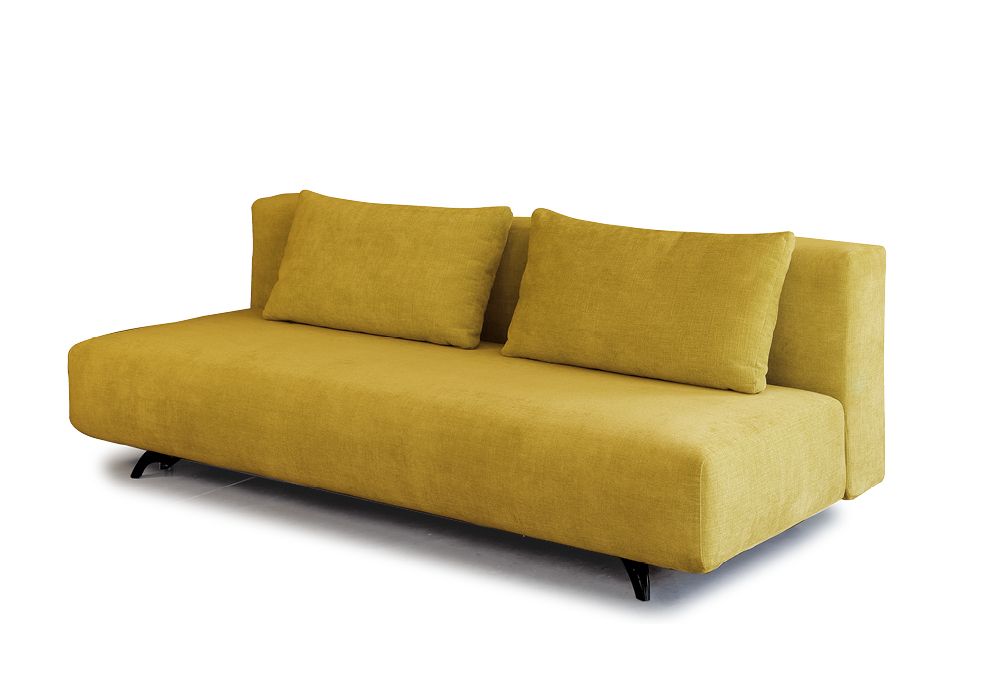 Un divano bianco è posizionato in un soggiorno, accanto a una finestra.