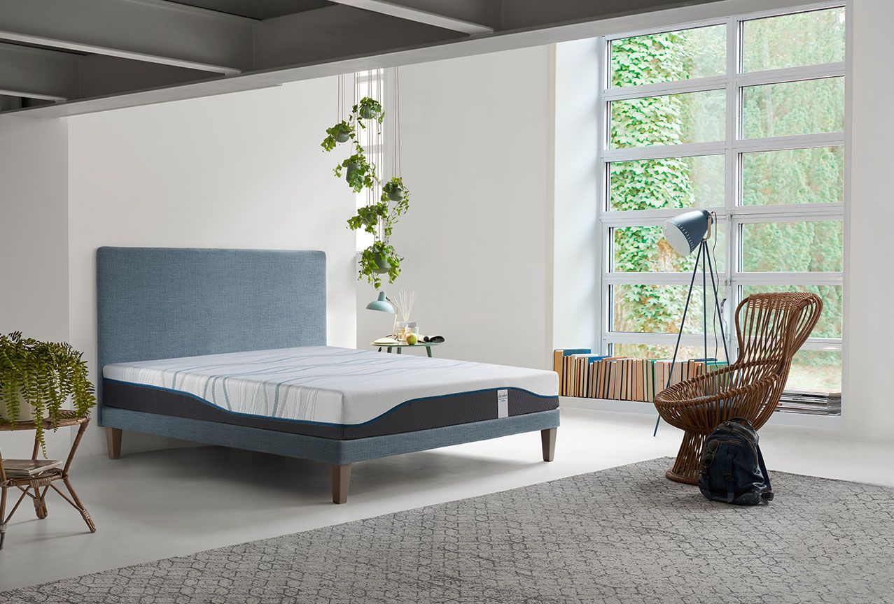 Una camera da letto con un letto, una sedia, un tavolo e una finestra.