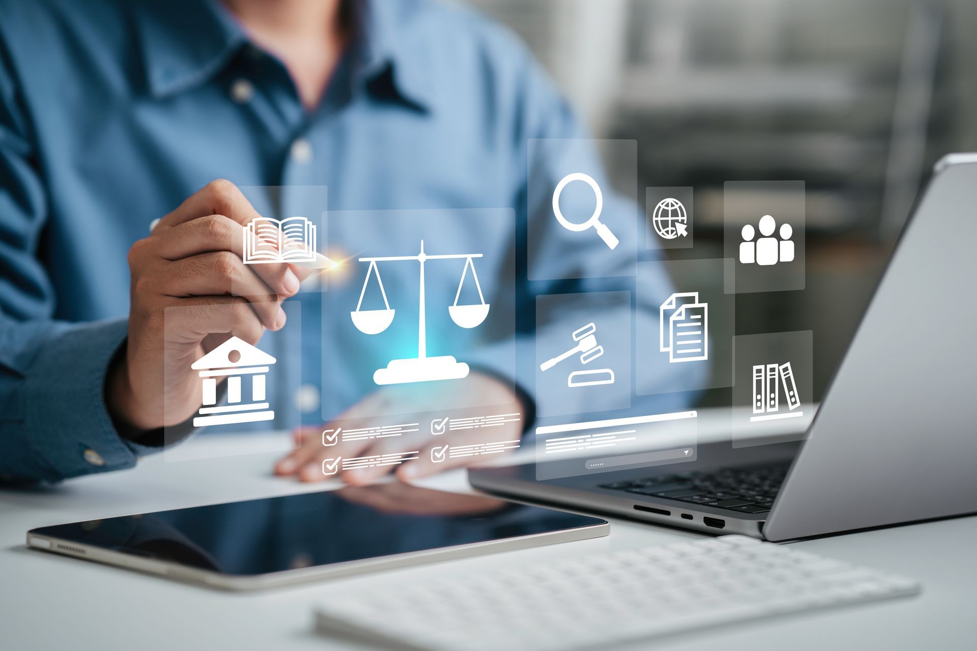 A lawyer with legal services icons coming from a laptop screen. A tablet & keyboard are on his desk A lawyer with legal services icons coming from a laptop screen. A tablet & keyboard are on his desk
