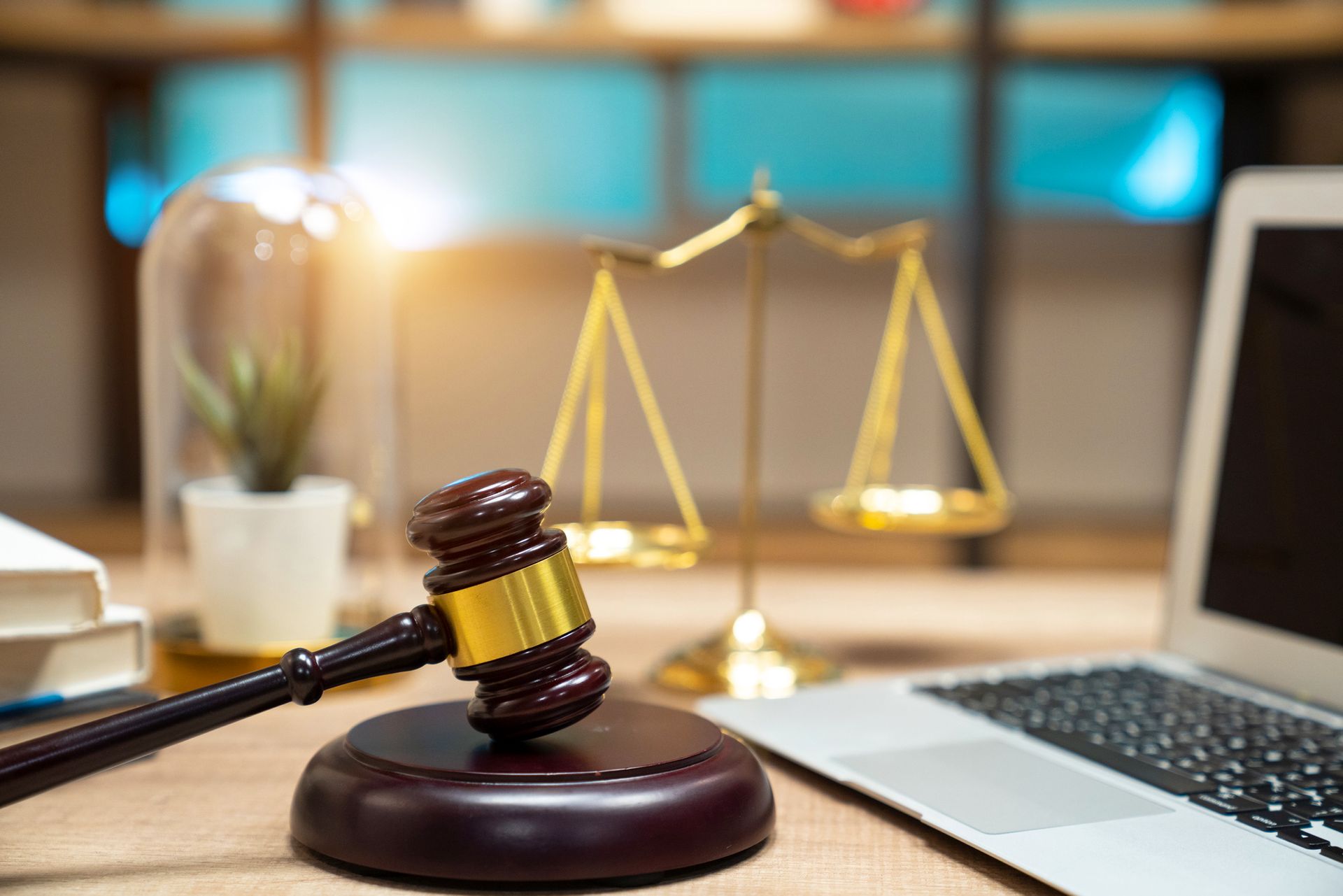 Close-up picture of a lawyer's workplace with a laptop and documents on top of a dark wooden desk.