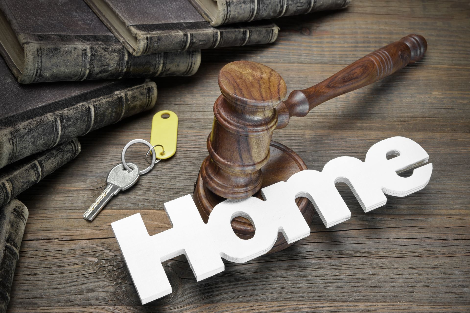 Gavel, house key, and law book on table representing conveyancing process. Gavel, house key, and law book on table representing conveyancing process.