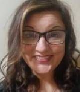 A close up of a woman wearing glasses and smiling.